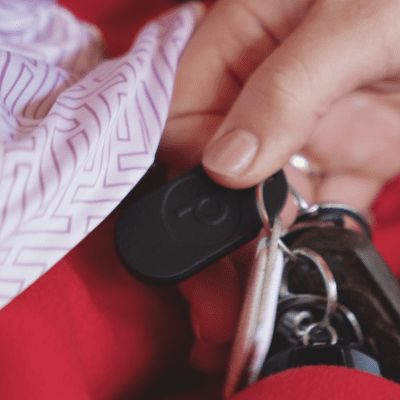 Woman pulling keys with Pick Protection panic button attached out of her bag