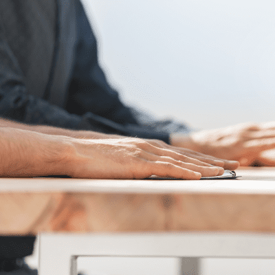 Close up of hand resting on a notepad on a desk